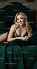Smiling blonde woman relaxing on green bed in black lingerie