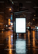 Illuminated Bus Stop Shelter with Advertising Board on Rainy Night