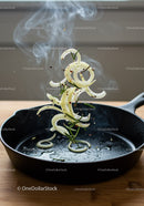 Sizzling onion rings and herbs tossed in cast iron skillet