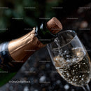 Champagne Bottle with Cork Popping and Bubbles in Glass