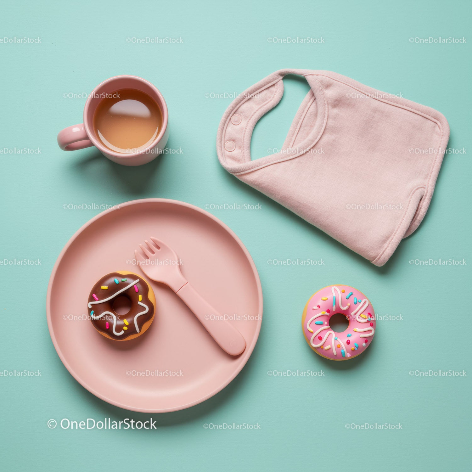 Pink baby bib with donuts and tea on blue background