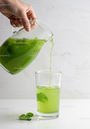 Refreshing green mint lemonade being poured into glass