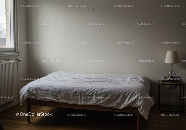 Minimalistyczna sypialnia z białym łóżkiem i nowoczesną szafką nocną