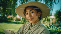 Young Woman Relaxing Outdoors Wearing Stylish Hat Reading a Book