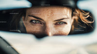 Close-up of Woman with Focused Eyes Looking through Rearview Mirror