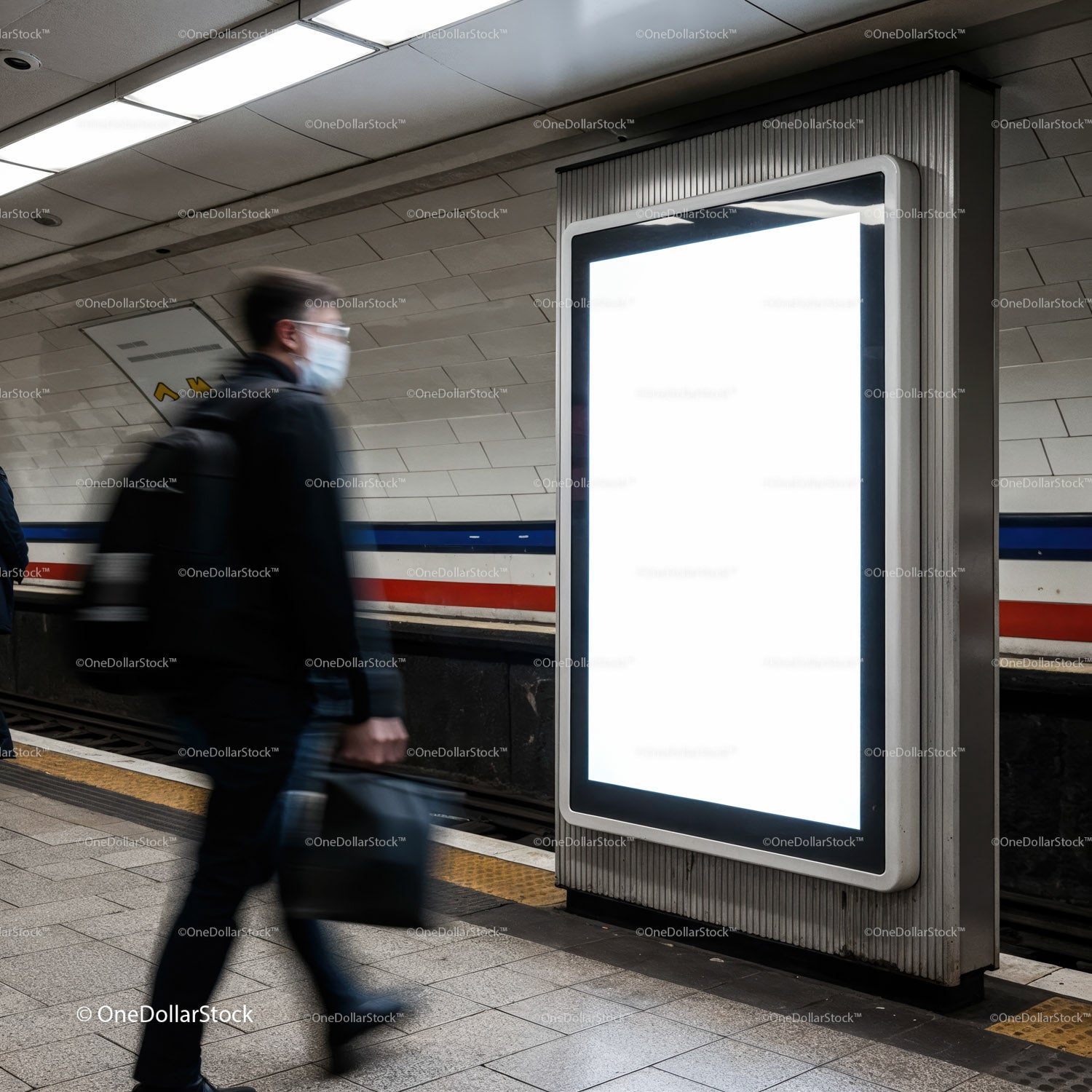 Commuter walking past blank digital billboard in subway station