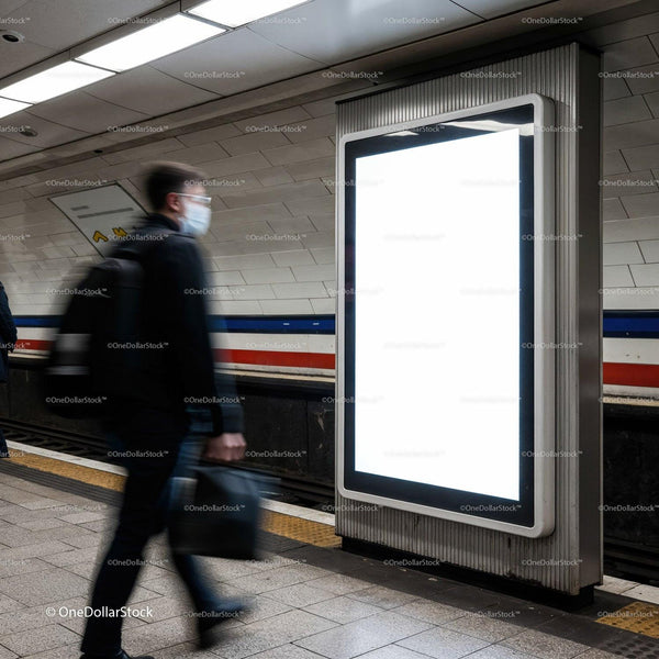 Commuter walking past blank digital billboard in subway station JPG Mockup Image