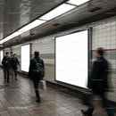 Blurred commuters walking past blank subway billboards