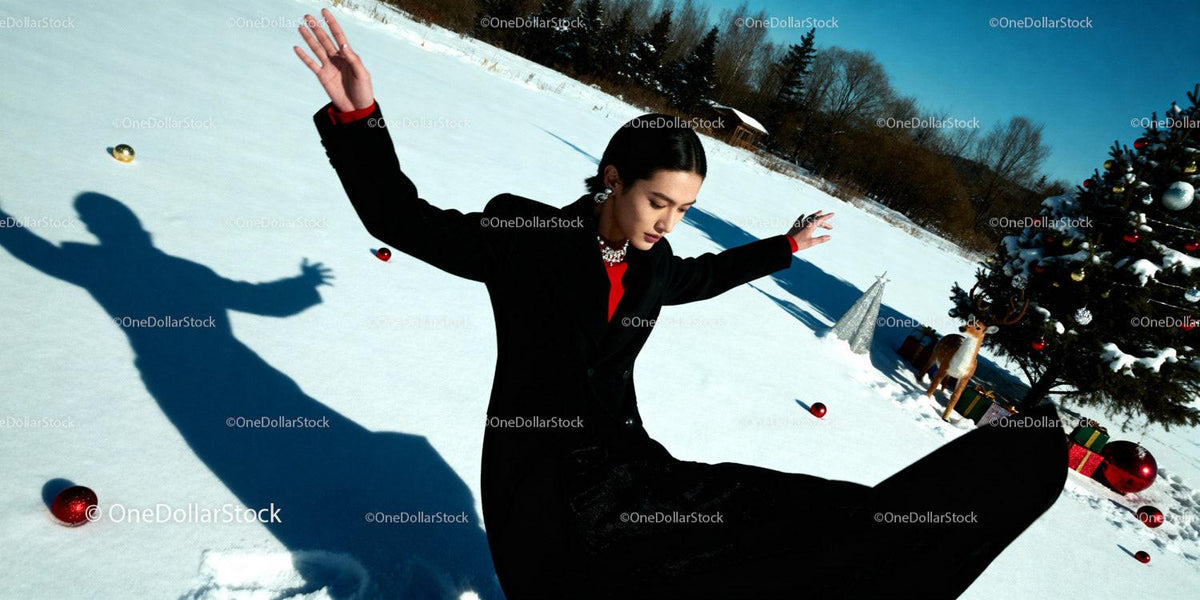 Woman in black coat enjoying winter snow with holiday decor