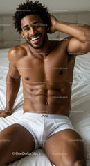 Smiling fit man relaxing on bed in white underwear