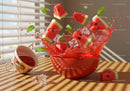 Fresh watermelon splashing in red bowl with mint leaves