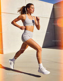 Fit young woman running outdoors in modern urban setting