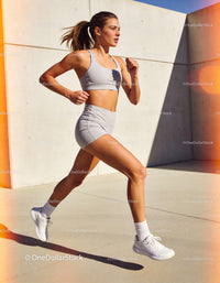 Fit young woman running outdoors in modern urban setting