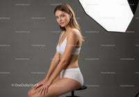 Young Woman in White Lingerie Sitting in Studio with Lighting