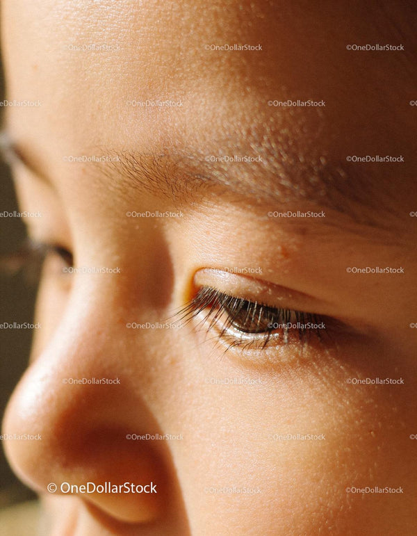 Close up of thoughtful child’s peaceful face in sunlight