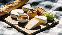 Artisan Cheese Platter with Fruit and Honey on Picnic