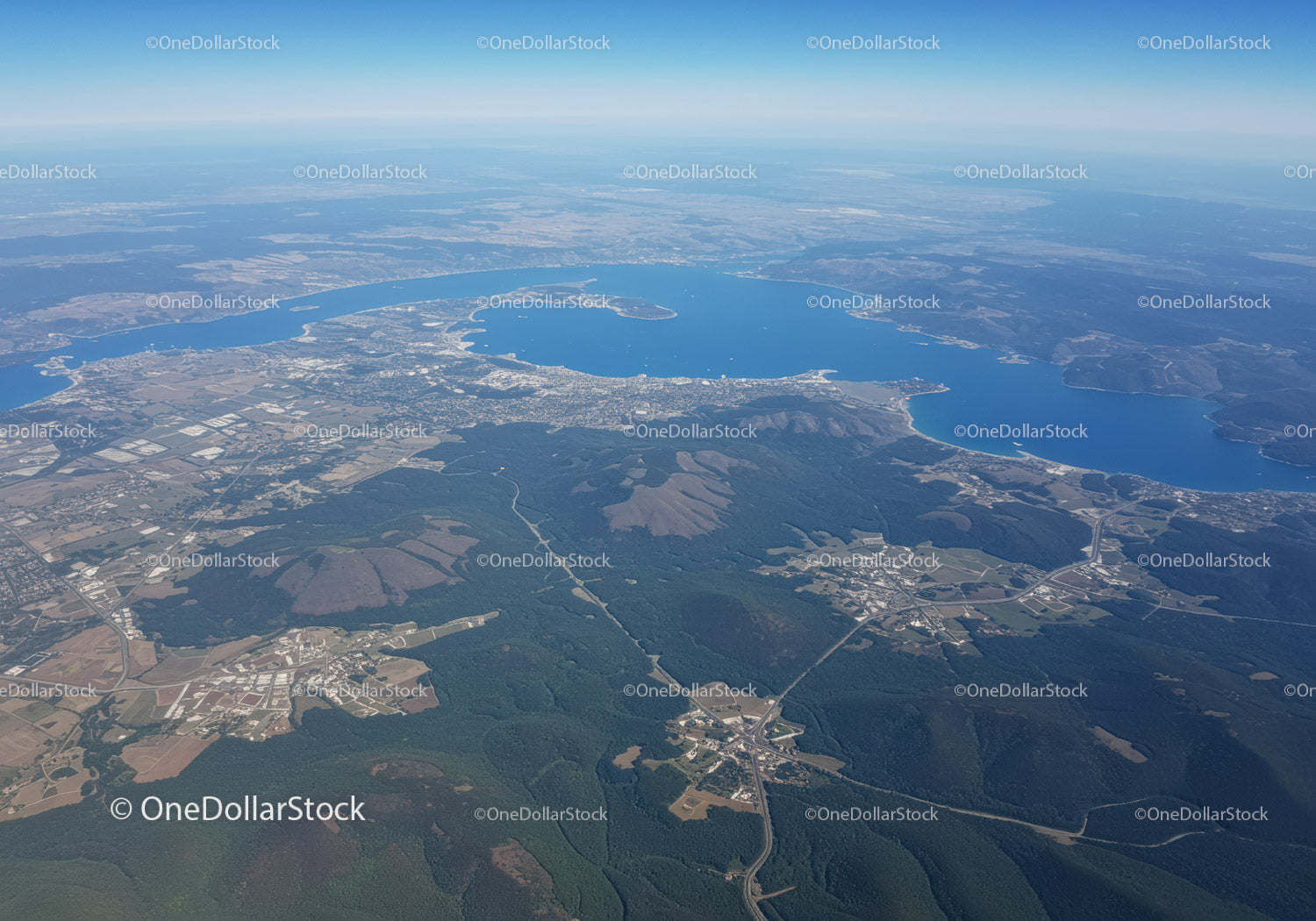Scenic Aerial View of a Blue Lake Surrounded by Green Forests and Mountains