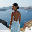 Elegant woman in blue dress overlooking ocean cliffs