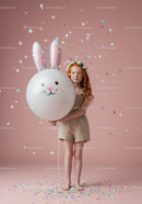 Redhead girl with flower crown holding bunny balloon