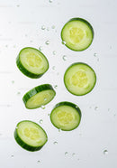 Fresh cucumber slices floating in clear water droplets