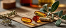 Amber and Gold Herbal Supplement Pills on Rustic Paper with Greenery