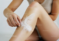 Close-up of a Woman Holding a White Feather with Bare Legs and Soft Light