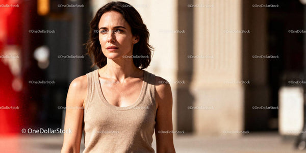 Thoughtful woman walking outdoors in warm sunlight