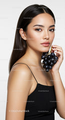 Elegant Woman Holding Black Grapes in Studio Portrait