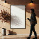 Blurred woman walking past blank wall poster with plant