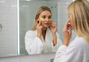 Woman Applying Eye Patches in Front of Mirror for Skincare