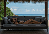 Relaxing Woman on Outdoor Sofa by the Sea with Scenic Ocean View