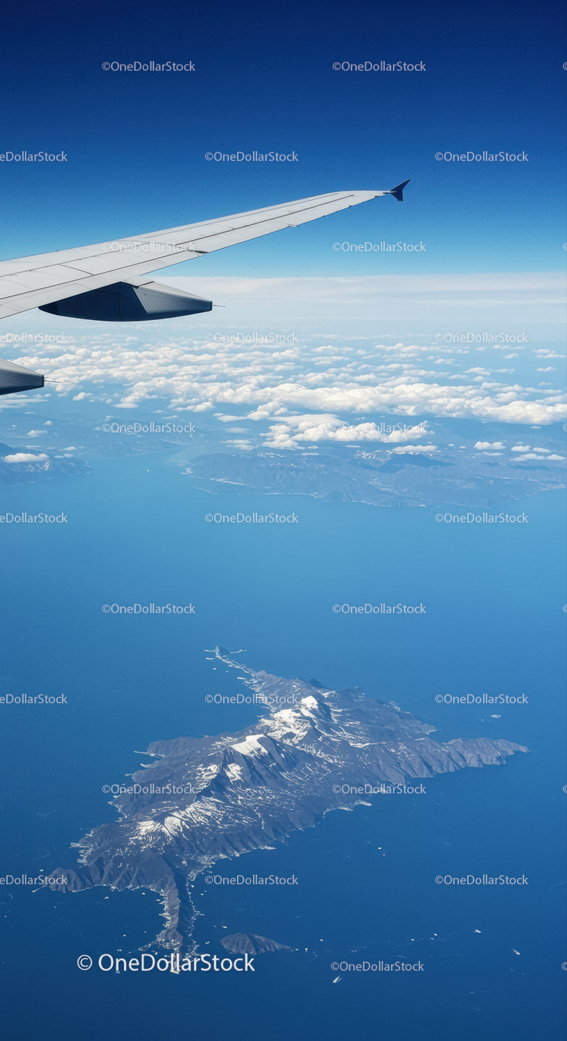 Scenic Aerial View of Snow-Capped Mountains and Ocean from Airplane Window