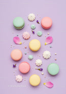 Colorful macarons and pastel meringues on purple background