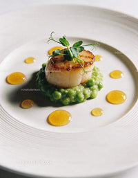 Seared scallop on pea puree with honey droplets