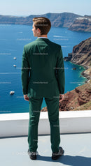Man in Green Suit Overlooking Blue Sea and Rocky Cliffs