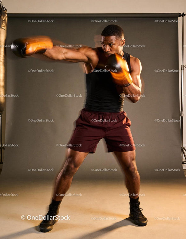 Focused boxer delivering a powerful punch in studio