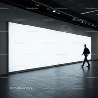Blurred man walking past large glowing billboard