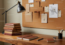 Cozy wooden desk with books and creative corkboard notes