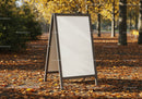 Blank sandwich board on path covered with autumn leaves