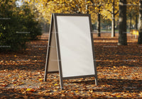 Blank sandwich board on path covered with autumn leaves