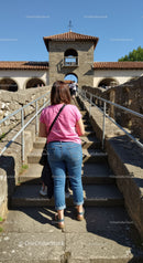Tourists Visiting a Historic Stone Castle with Tower and Arched Entry