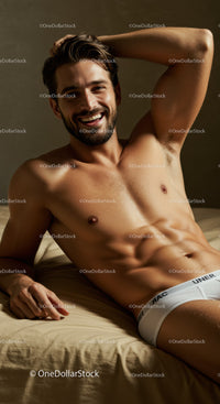 Smiling muscular man relaxing comfortably on bed