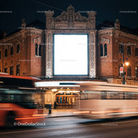 Historic theater facade with bright billboard at night