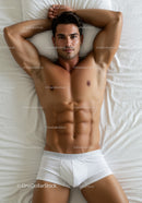 Fit young man relaxing on bed in white underwear