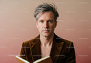 Elegant Mature Man with Gray Hair Reading Book in Modern Studio
