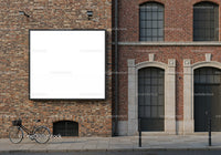 Vintage bicycle parked near brick building with blank billboard