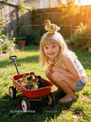Young girl smiling with ducklings in red wagon outdoors