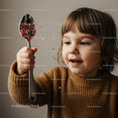 Toddler playing with colorful sprinkles on spoon
