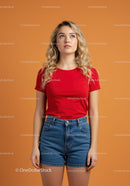 Young woman in red shirt looking upward thoughtful