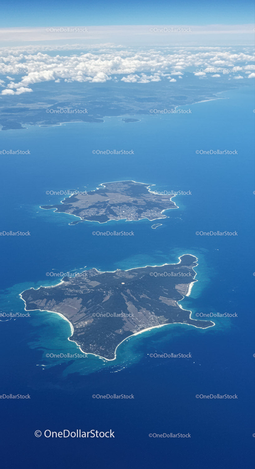 Aerial View of Remote Islands Surrounded by Blue Ocean and Cloudy Sky